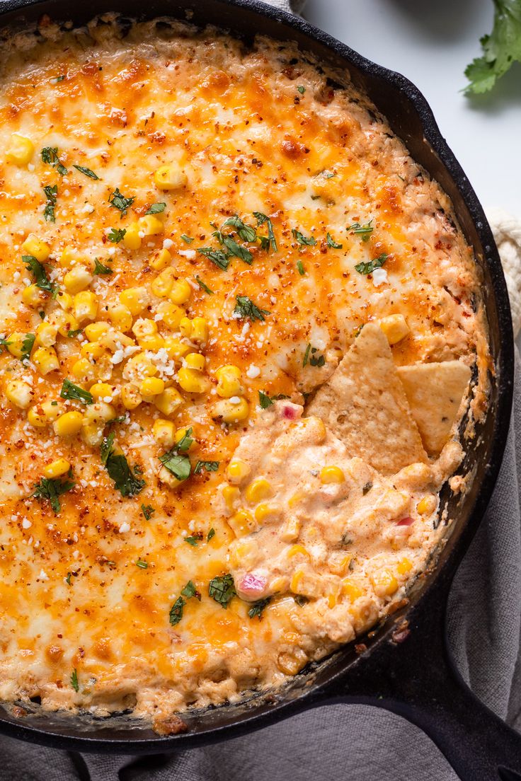 a skillet filled with corn and tortilla chips on top of a table