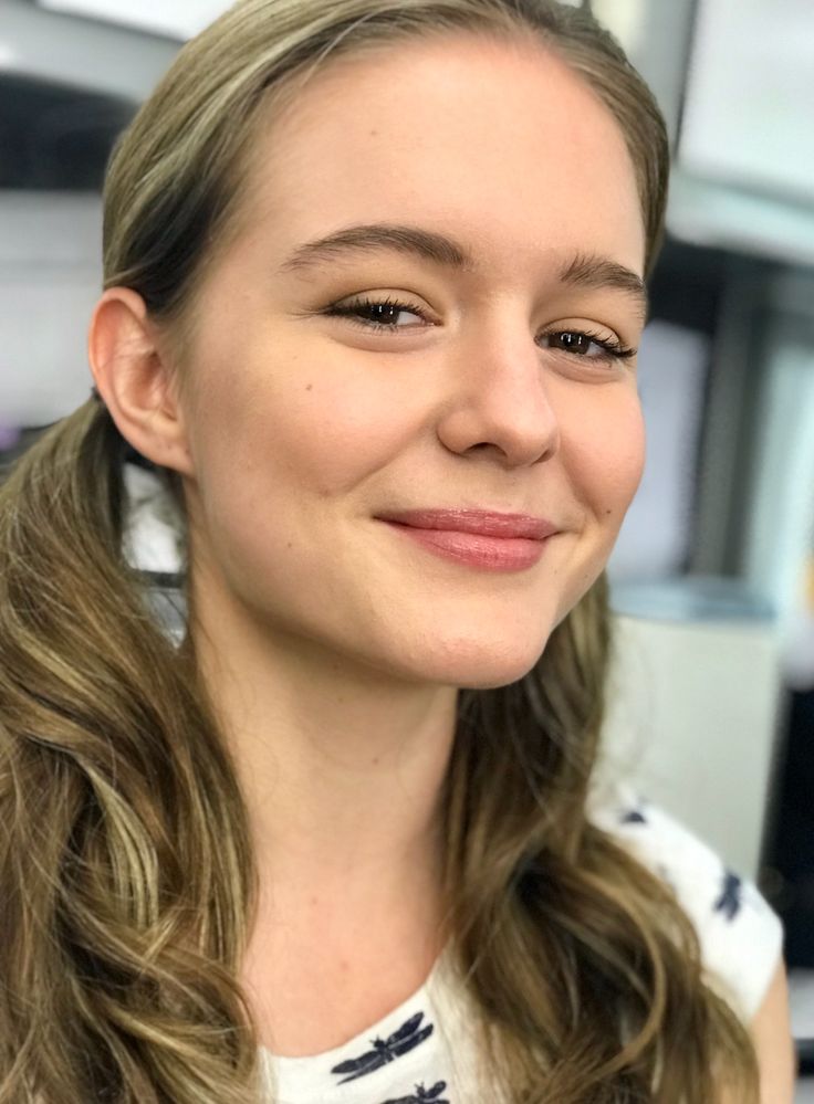 a woman with long hair smiling at the camera