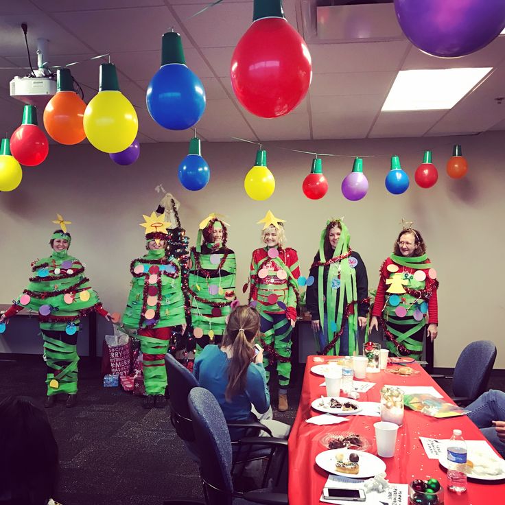 a group of people dressed in costumes standing around a table with food and drinks on it