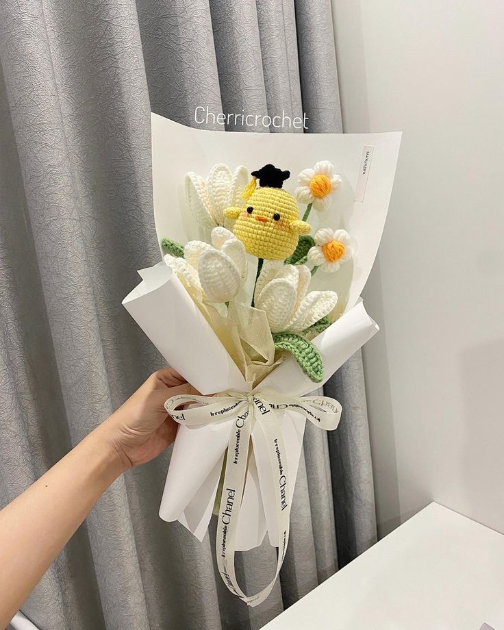 a person holding a bouquet of flowers in front of a window