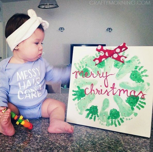 a baby sitting next to a christmas card