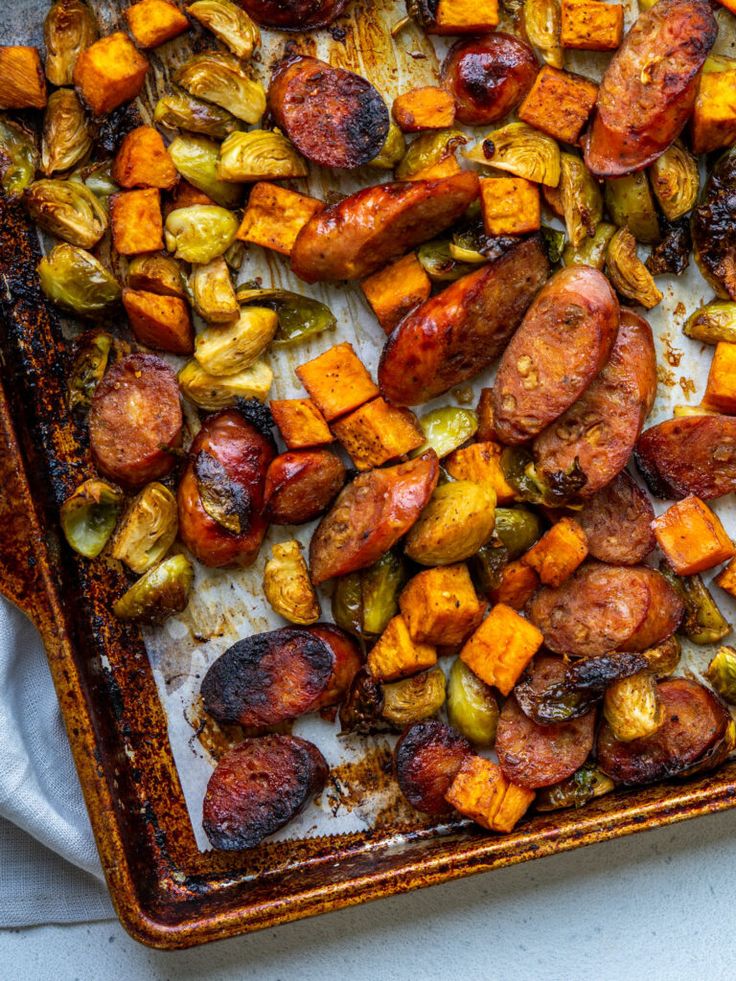 roasted vegetables and sausage on a baking sheet