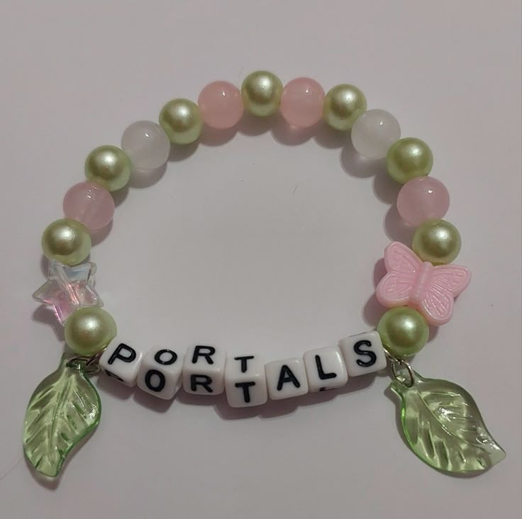 a bracelet with beads and charms that say portals on the bead, leaves