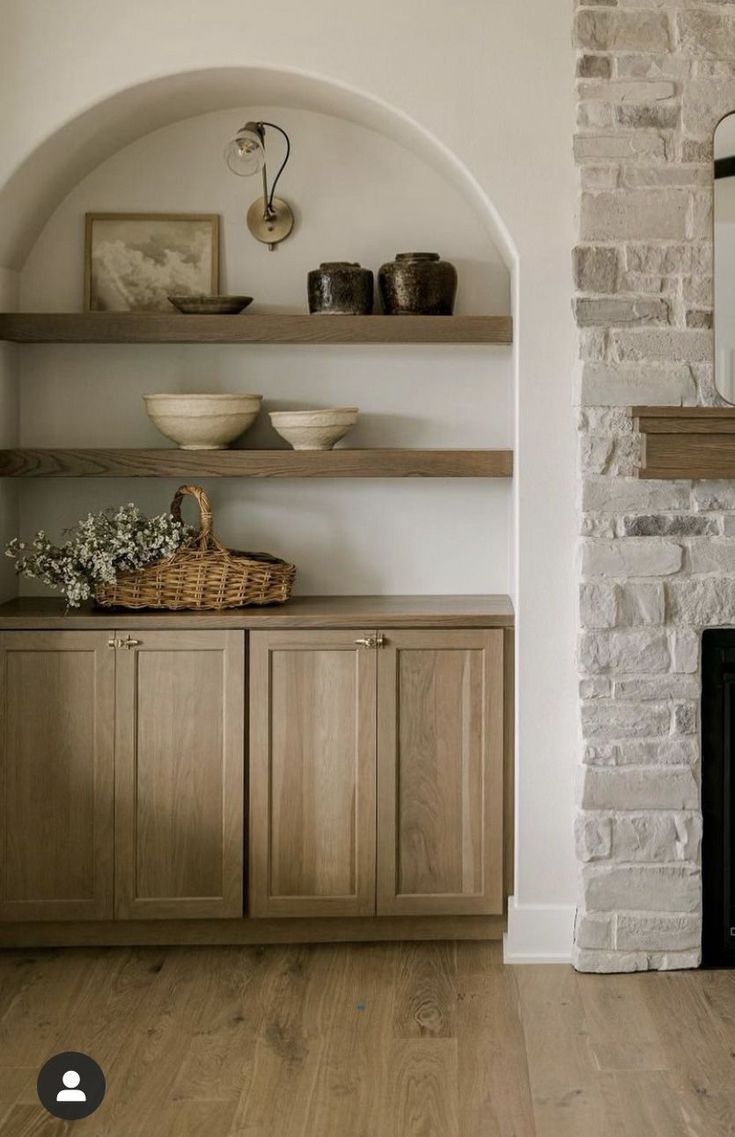 a living room with a fireplace and shelves