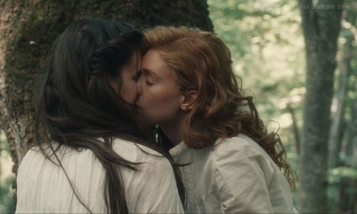 two women kissing each other in the woods