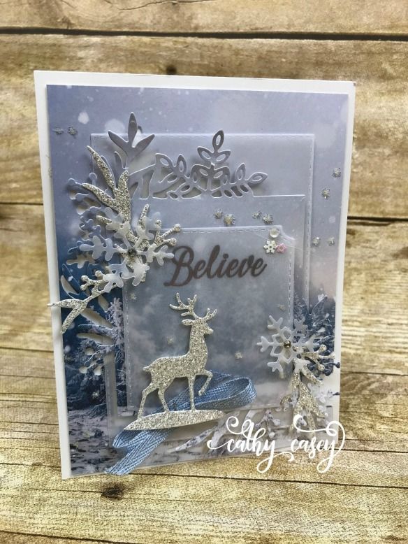 a christmas card with reindeers and snowflakes on the front, in silver foil