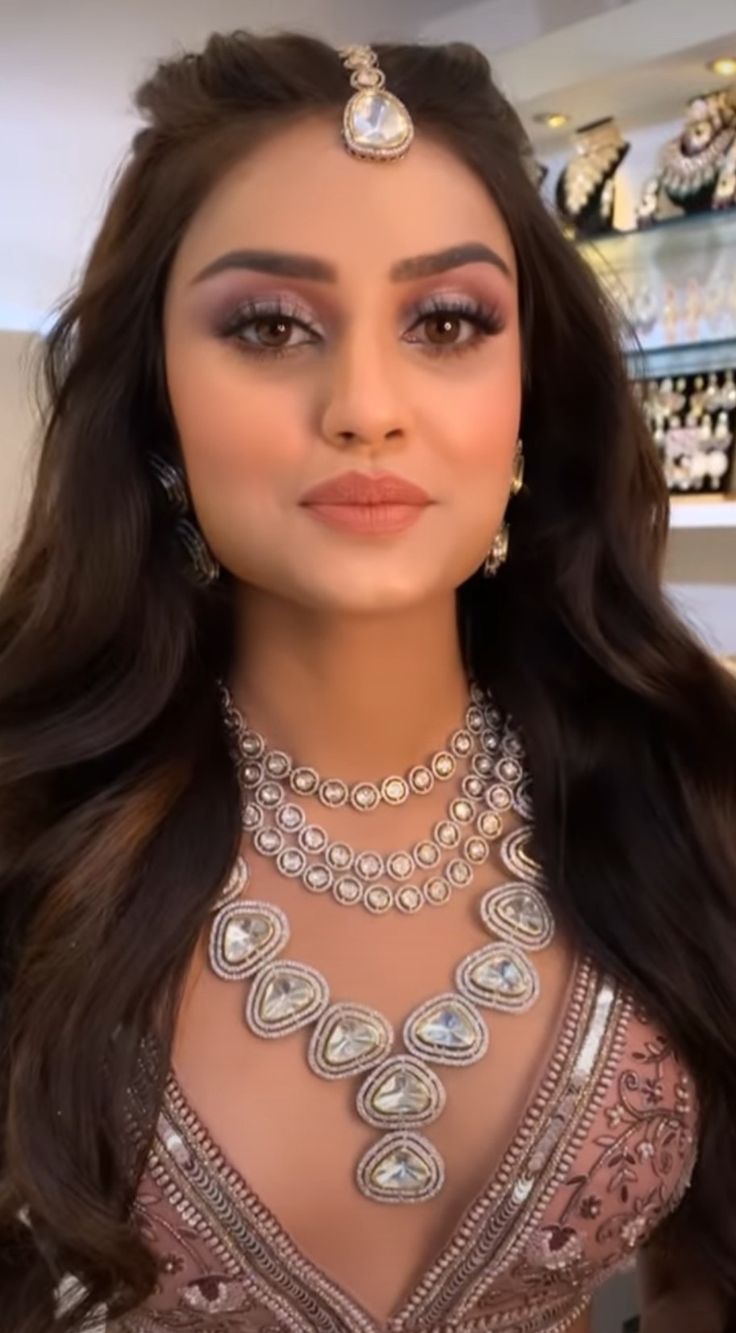 a woman with long hair and jewelry on display