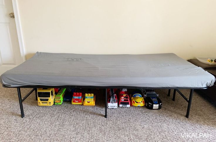 a bed with toy cars underneath it in a room