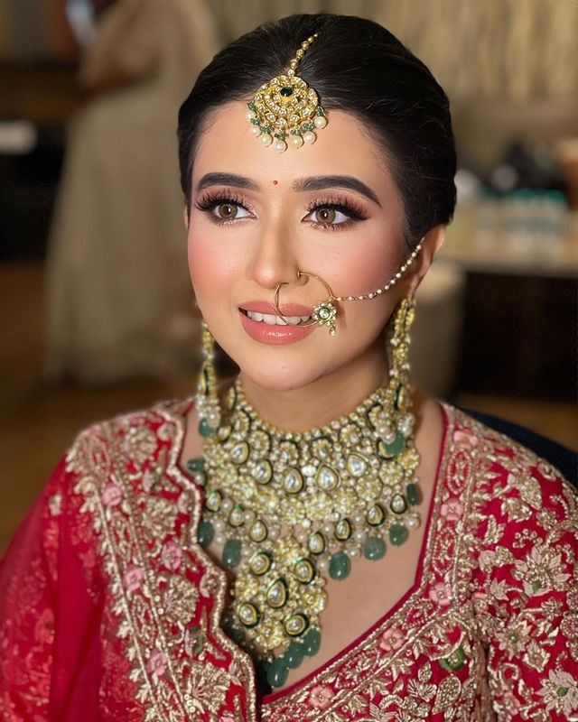 a woman in a red and gold bridal outfit