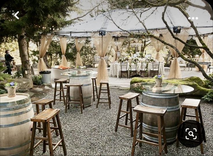 an outdoor area with several wooden barrels and tables set up for people to sit at