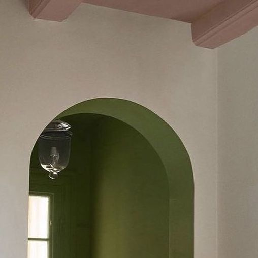 an arched doorway in a white room with green walls and wood flooring on either side