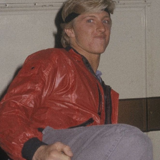 a young man in a red leather jacket