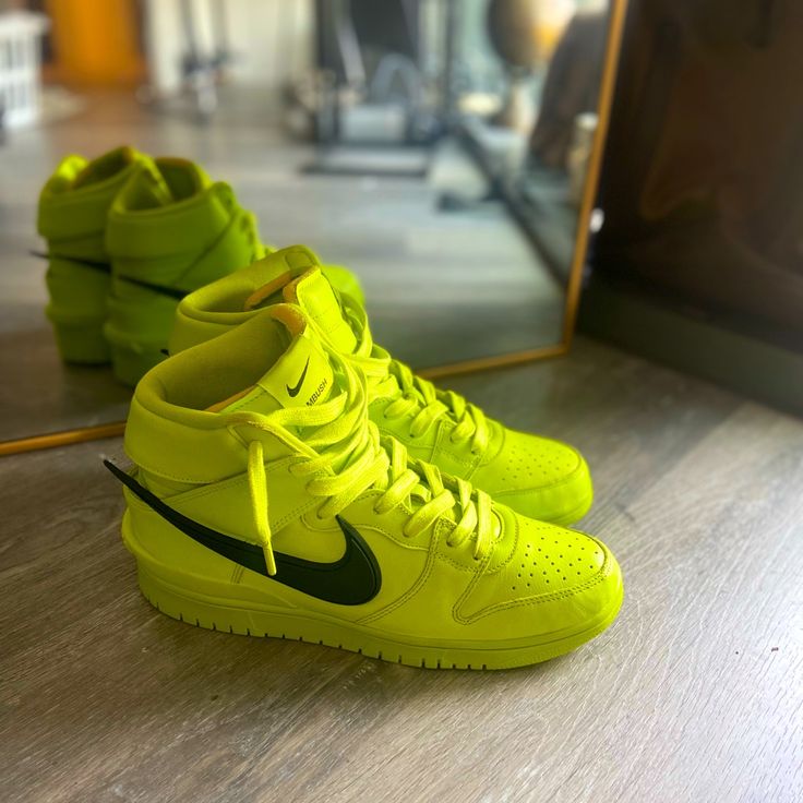 The Ambush X Nike Dunk High “Flash Lime” Is A July 2021 Collaboration Between The Japan Based Jewelry Brand And Nike On The Vintage Basketball Shoe. The “Flash Lime” Succeeds Ambush’s Previous Explorations Of The Dunk Model, Including The “Spruce Aura,” “Deep Royal,” And “Lethal Pink” Iterations. Like Those Colorways, The “Flash Lime” Arrives In A Retro-Modern Construction That Pushes Forward A Futuristic Look For The Classic Basketball Shoe. Vibrant Flash Lime Leather Covers The Entire Upper, Save For The Large Black Rubber Swoosh Logo That Extends Past The Heel. The Perforated Toe, Mid-Panel, And Raised Leather On Overlays Are All Cast In The Head-Turning Neon Gre Nike Green High-top Sneakers With Branded Insole, Green Synthetic High-top Sneakers For Light Sports, Green Synthetic High-top Running Sneakers, Green Synthetic High-top Sneakers, Green Synthetic High-top Sneakers For Running, High-top Sneakers For Light Sports, Neon Yellow Sneakers With Rubber Sole For Streetwear, Green High-top Sneakers For Outdoor, Green High-top Sneakers