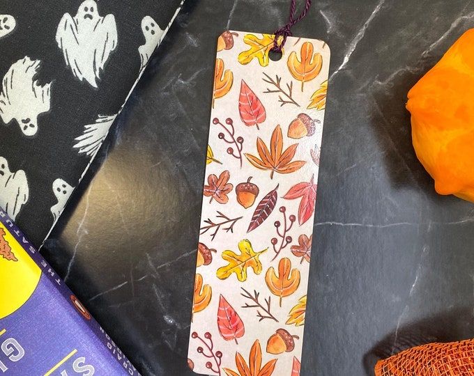 a bookmark is sitting on a table next to some candy and other halloween decorations