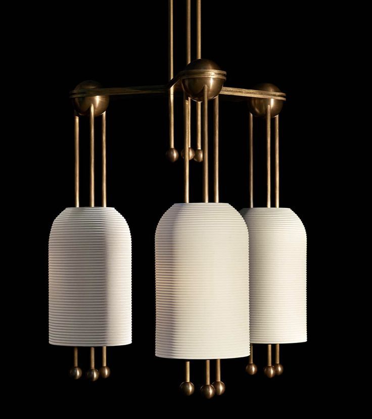 three white lamps hanging from the ceiling with gold fixtures on each one side and two different shades