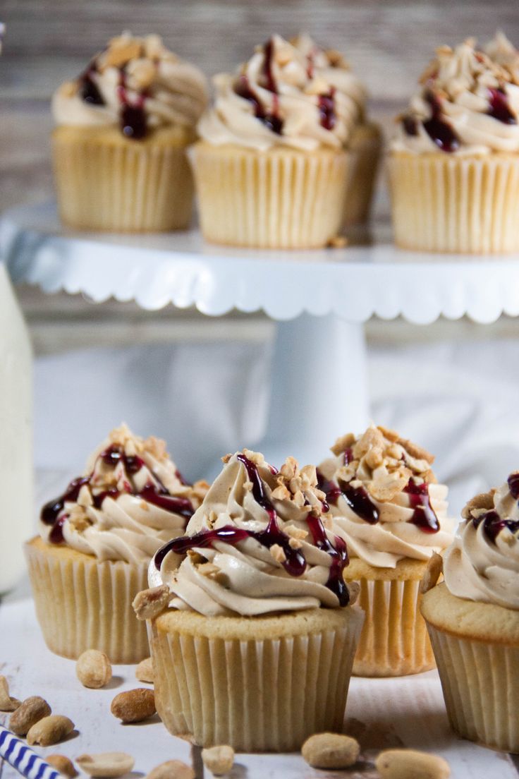 several cupcakes with frosting and nuts on a table