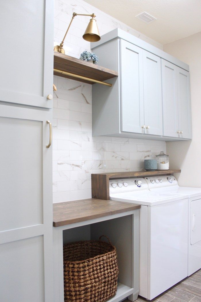 a white washer and dryer sitting inside of a laundry room next to cabinets