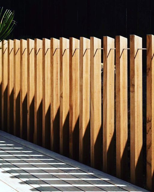 a wooden fence is next to a potted plant