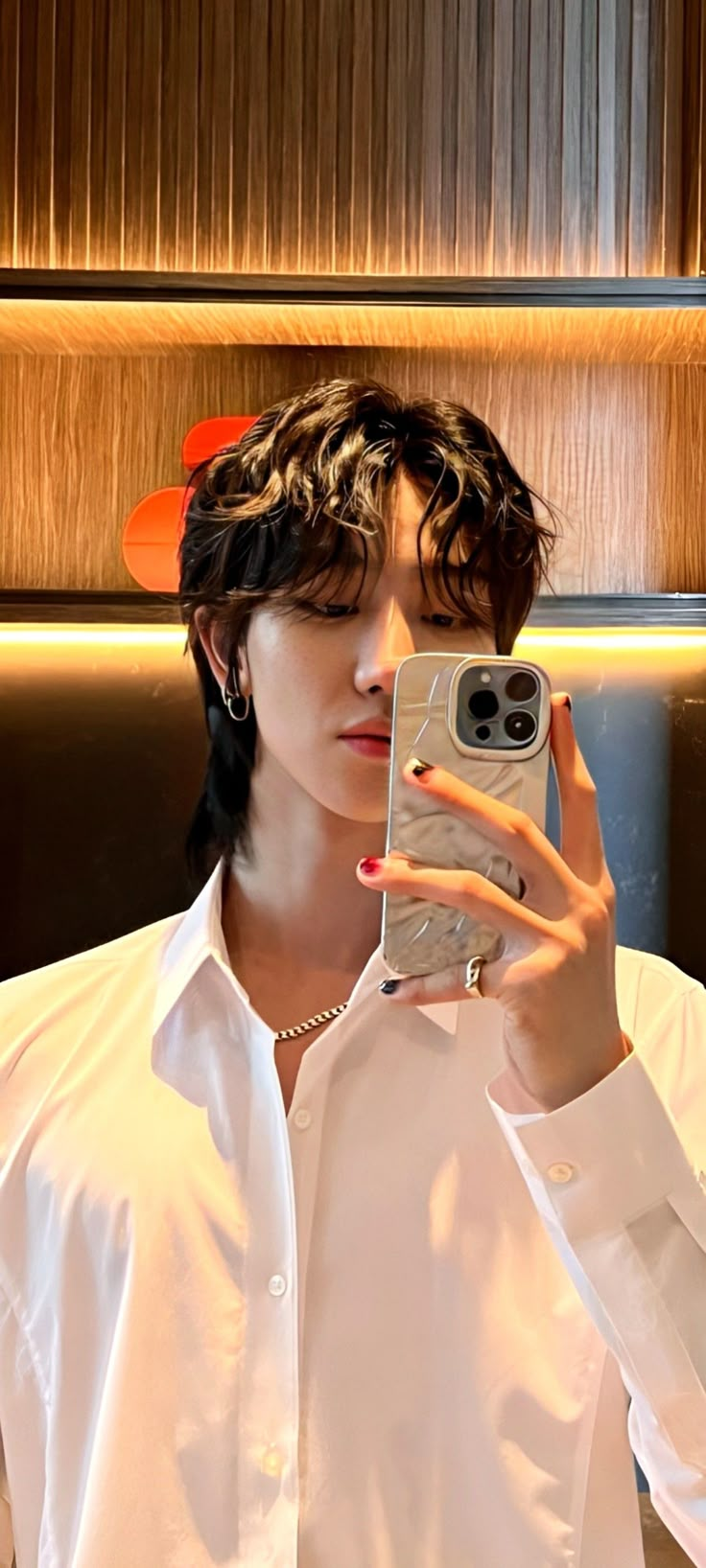 a woman taking a selfie in front of a mirror with her cell phone up to her ear