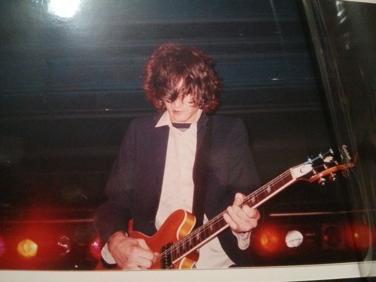 a young man playing an electric guitar on stage