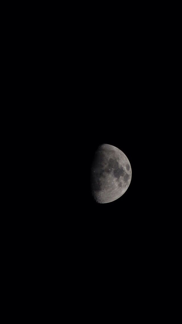 the moon is seen in the dark sky