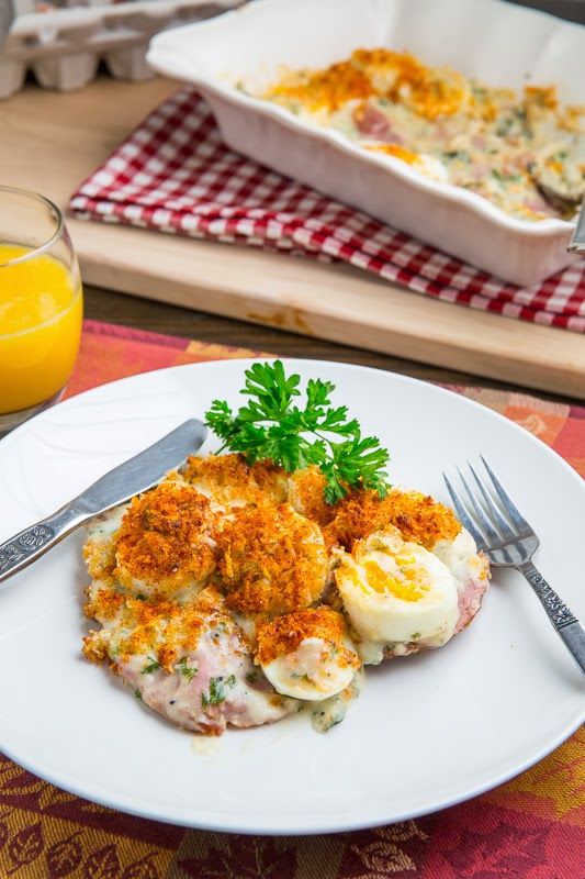 a white plate topped with food next to a glass of orange juice