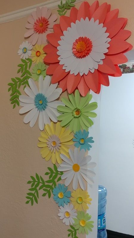 the paper flowers are hanging on the wall next to the refrigerator freezer in the kitchen