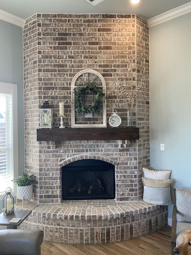 a living room with a fire place and a dog sitting on the couch in front of it