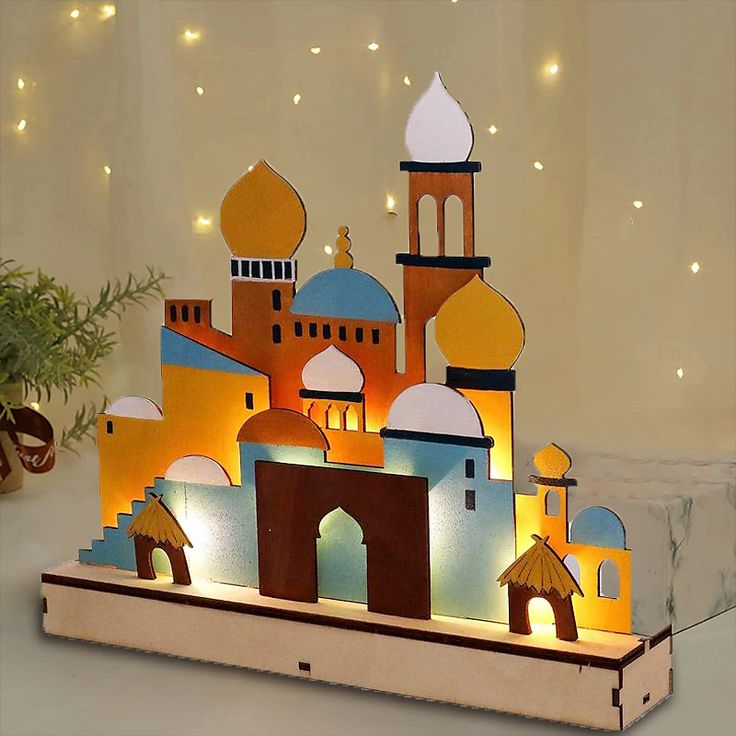 an illuminated paper cutout of a mosque