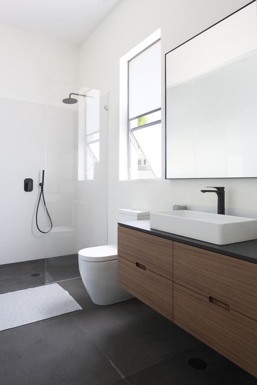 a bathroom with a sink, toilet and shower in it's own area is shown