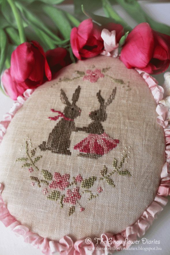 a close up of a piece of cloth on a table with flowers in the background