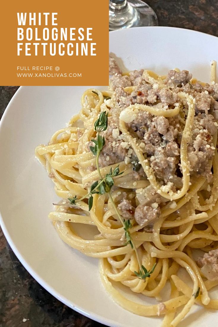 a white plate topped with pasta and meat