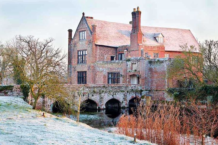 an old brick building with a bridge in front of it on a frosty day