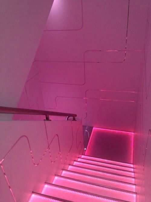 the stairs are lit up with pink lights in an area that looks like it has been painted