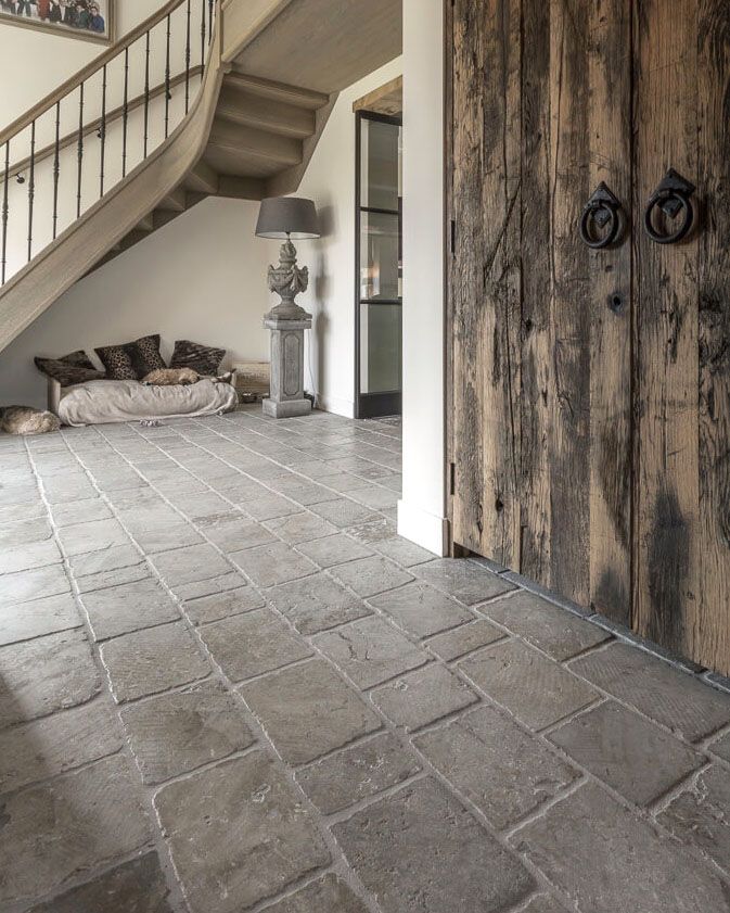 an open door leading to a living room with stairs and couches in the background