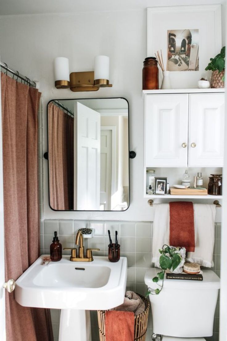 a bathroom with a toilet, sink and mirror