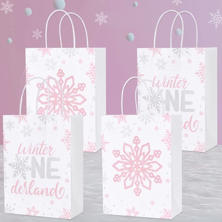 three white bags with pink snowflakes on them and the words winter one do