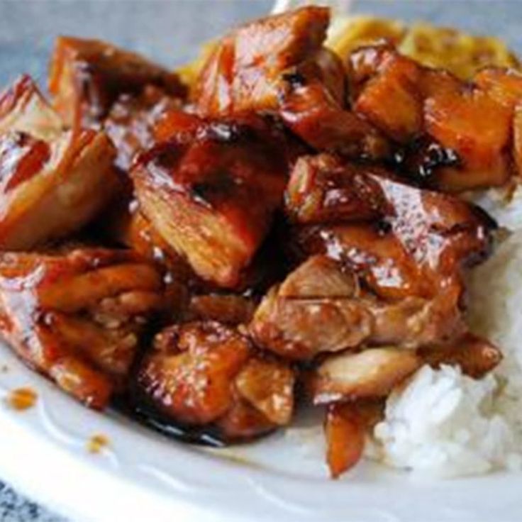 chicken and rice on a white plate with sauce