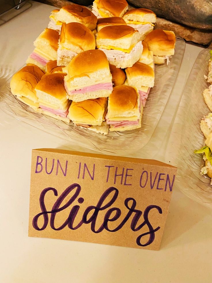 buns in the oven sliders are sitting on a table next to a sign