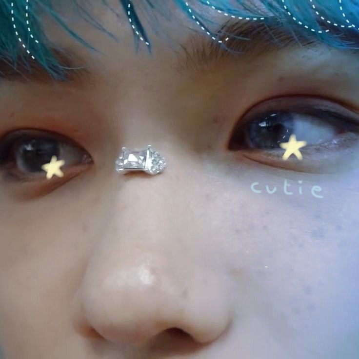 a close up of a child's face with fake stars on their forehead and nose