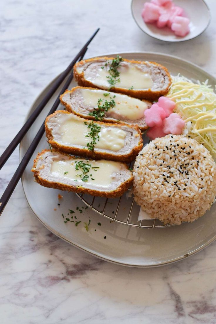 a plate with some food on it and chopsticks next to the plate,