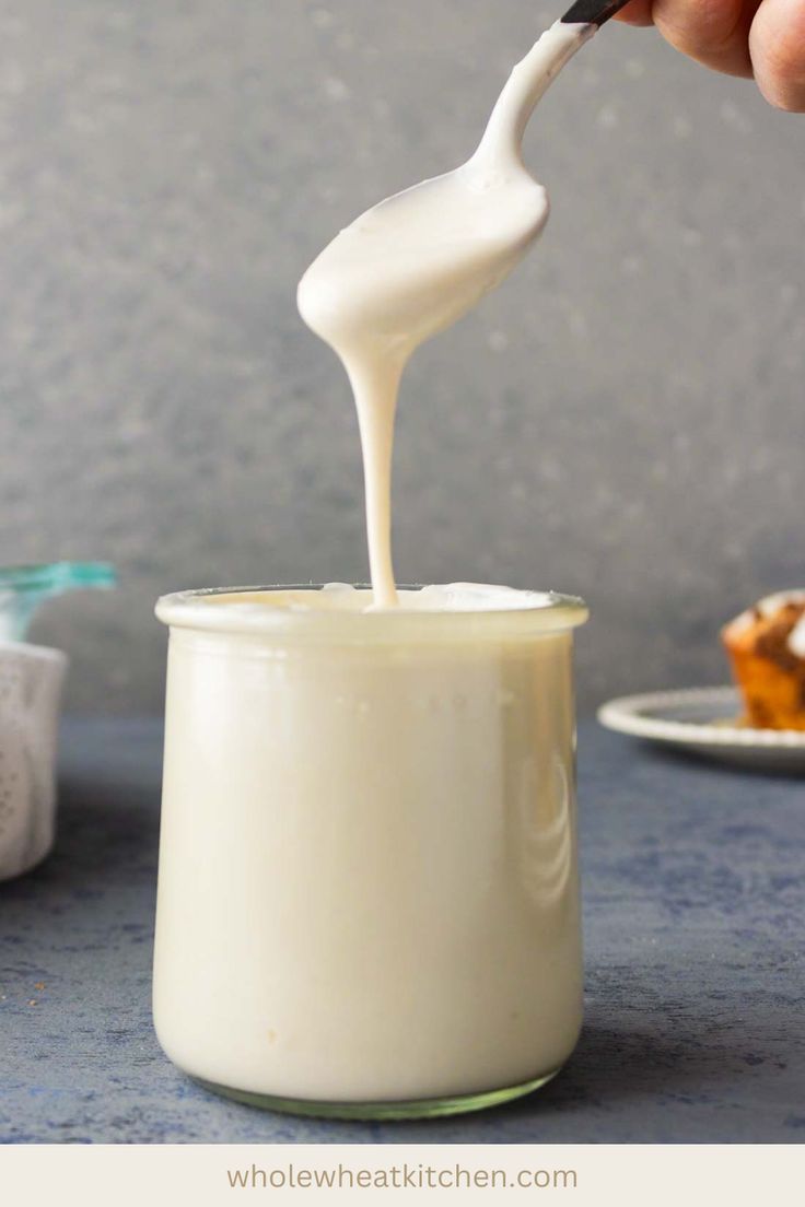 someone is pouring milk into a glass jar