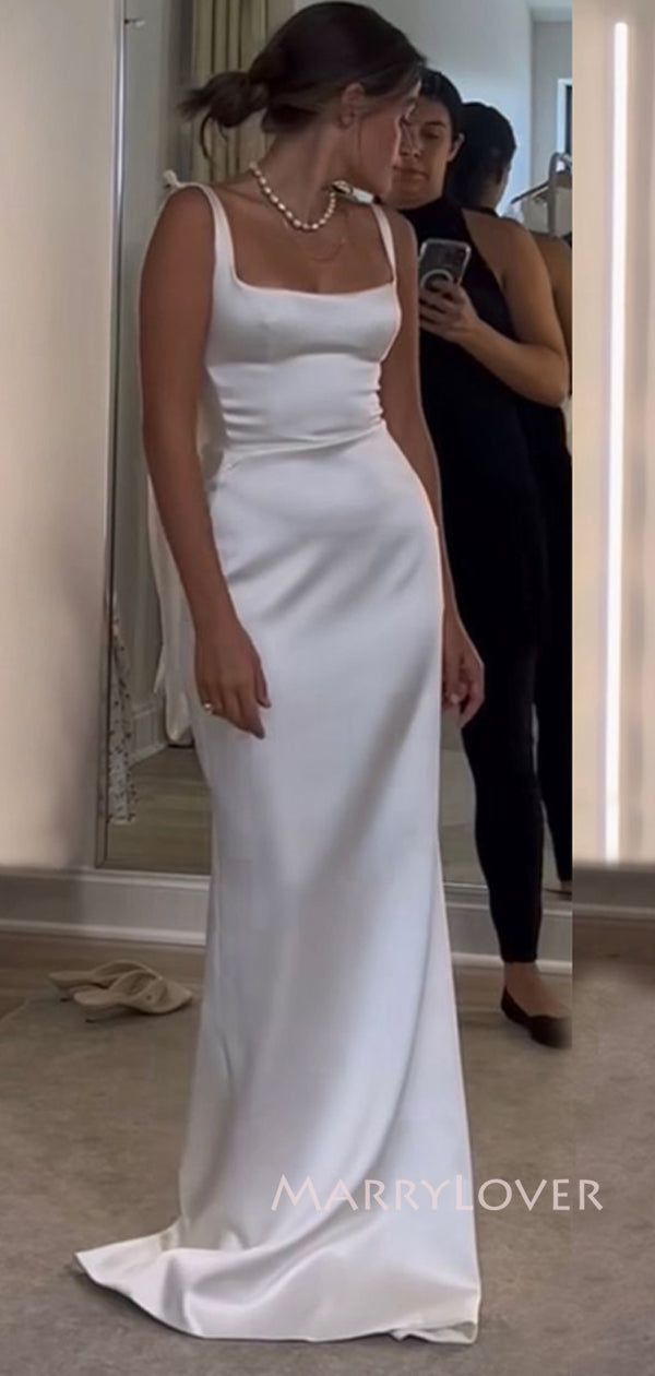 a woman standing in front of a mirror wearing a white dress