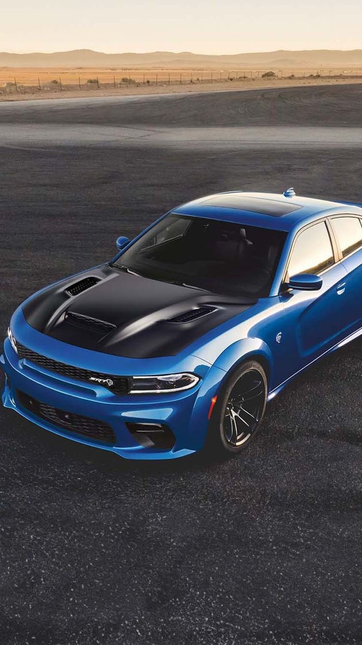 a blue dodge charger parked in an empty lot