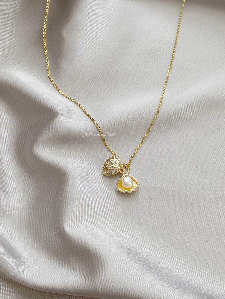 "△ DETAILS * 100% Genuine natural freshwater pearls, real pearl * Natural white color button shaped pearls, 5-5.5mm size, AAAA grade * 14K gold plated seashell/shell clam/oyster, with faceted cubic zirconia * 18K gold vermeil sterling silver chain, 18 inches (45cm) length * Delicate and daily wear necklace, perfect for yourself or as a gift * Ready for gifting, packed in a beautiful jewelry box * Handmade in USA ♥ Pearl Size: 5-5.5mm ♥ Pearl Shape: Button ♥ Pearl Color: White ♥ Chain Length: 18 Pearl In Shell Necklace, Pearl Clam Necklace, Cute Pearl Jewelry, Pearl Shell Charm Jewelry, Pearl White Shell Pearl Necklace With Pendant, Pearl Drop Shell Pearl Necklace, Pearl White Shell-shaped Necklace With Pearl Pendant, Shell-shaped Pearl Drop Necklace, Pearl White Shell Necklace With Pearl Drop