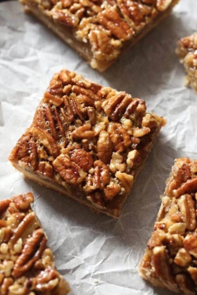 several pieces of pecan bar sitting on top of a piece of wax paper