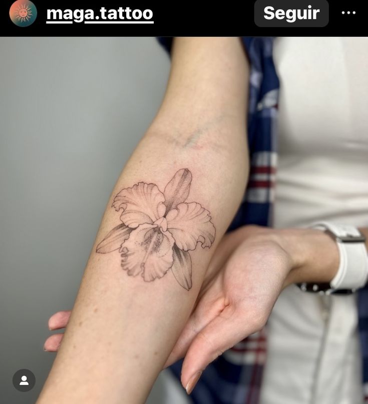 a woman's arm with a flower tattoo on it