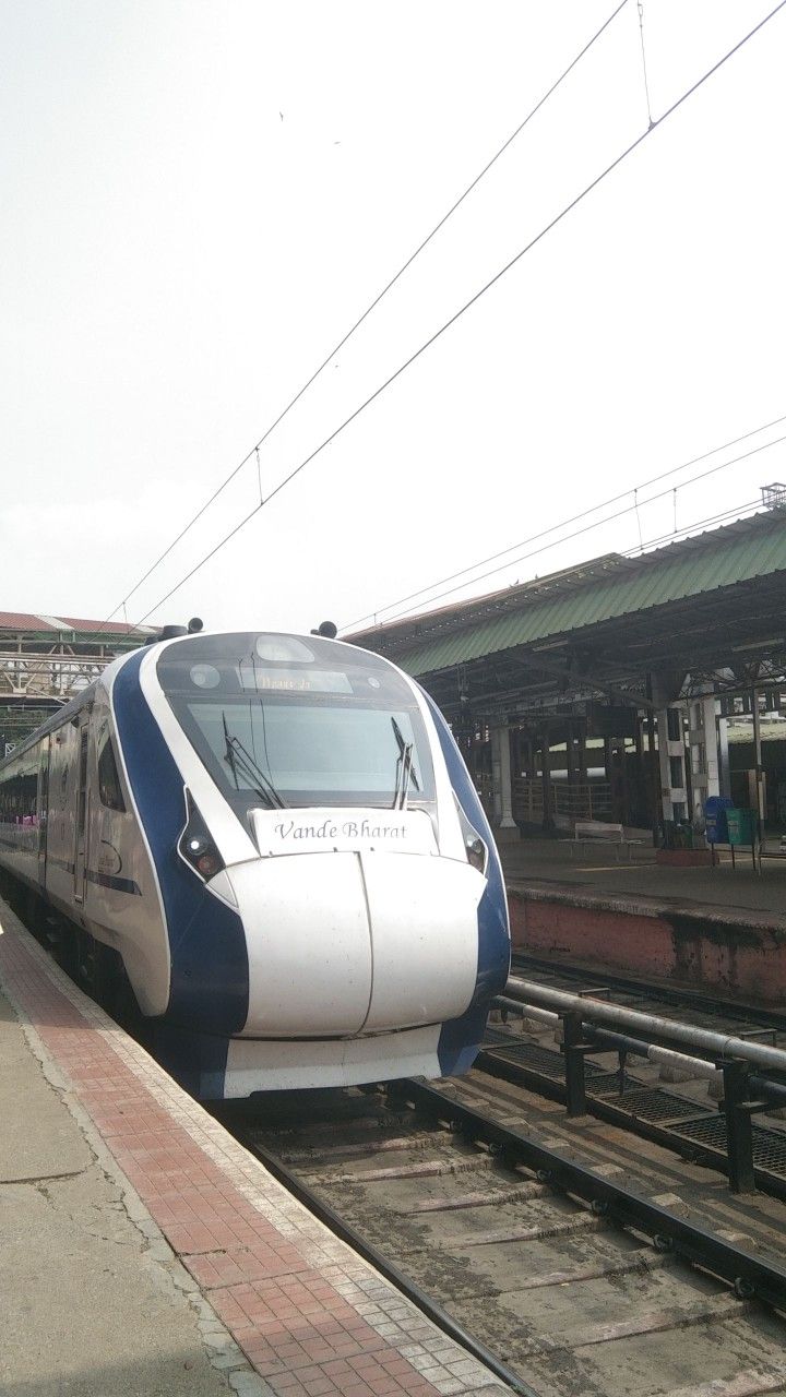 a blue and white train is on the tracks next to a platform at a station