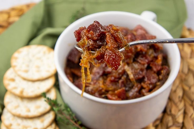 a spoon full of food with crackers on the side