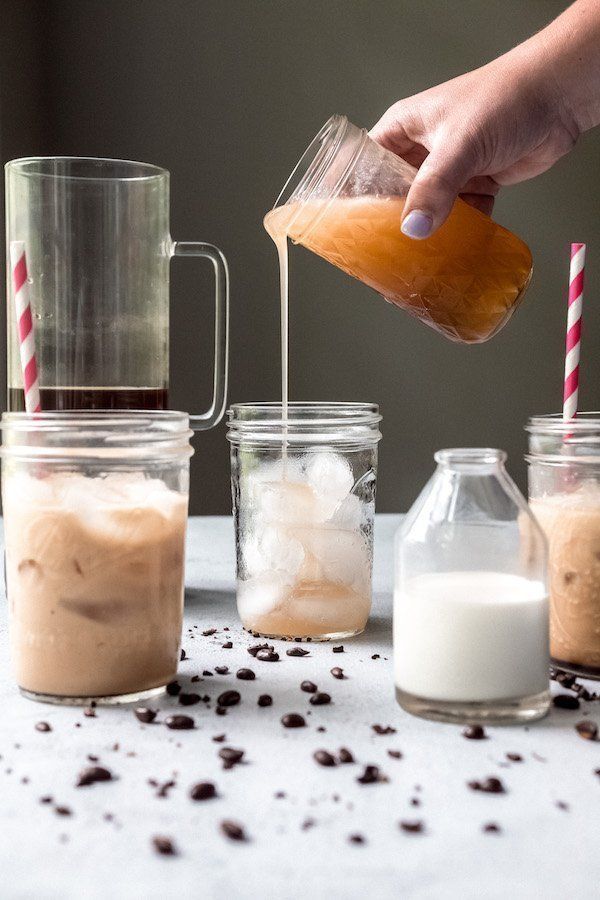 someone is pouring something into some jars with straws and chocolate chips on the table